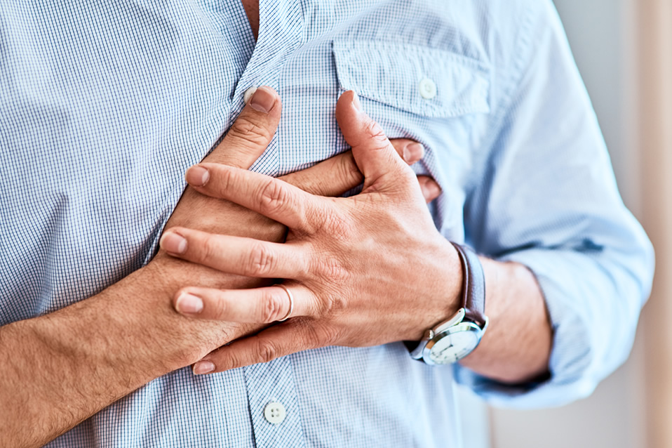 Person holding chest, possibly in pain.